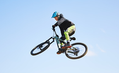 Image showing Bicycle, man and jump in blue sky for competition, freedom and adventure with mockup space. Athlete, sports and bike in air for action, cardio race and courage for stunt performance, power or contest