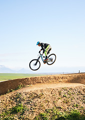 Image showing Cycling, sports and man in air on bicycle for adrenaline on adventure, freedom and jump for speed. Mountain bike, tricks and cyclist for training, exercise and fitness on dirt road, trail or track