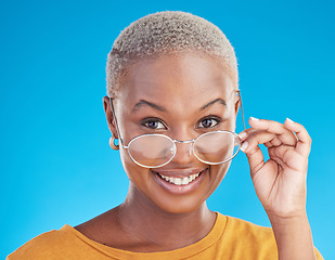 Image showing Happy, portrait and black woman with glasses on a blue background for stylish, trendy and fashion. Cool, smile and headshot of an African girl or optometry model with eyewear for vision and eye care