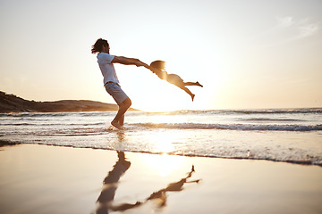 Image showing Father, spin girl kid and beach with games, holding hands or sunset for bonding together by waves. Dad, female kid and swing for love, care or play by sea, silhouette or family on vacation in summer