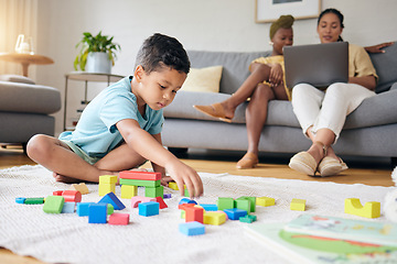 Image showing Play, toys and child on floor with parents on sofa for learning, development and education. Lgbtq family, home and boy with building blocks for fun, relax and games with lesbian mothers on laptop