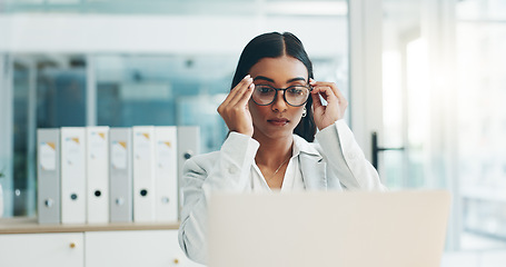 Image showing Business woman, glasses and working on laptop in office for planning, reading email and internet research in law firm. Indian lawyer, attorney and focus at computer to start legal analysis in company