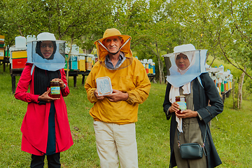 Image showing Portrait of Arab investors with a beekeeper in a large honey production farm