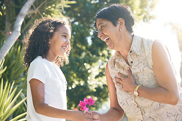 Image showing Flower gift, child or grandmother in park bonding together on mothers day with care, love or support. Kid, family or girl holding hands or giving a happy mature woman a floral present in retirement
