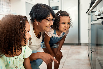 Image showing Baking, oven and a senior woman with her grandchildren in the kitchen of a home together for cooking. Family, children and an elderly grandmother with female kids in the house for learning or growth