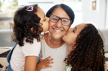 Image showing Children kissing their grandmother on her cheek with love, care and happiness in the living room. Happy, smile and portrait of senior woman hugging her girl kids in the lounge of the family home.
