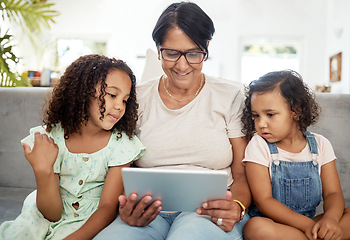 Image showing Tablet, bonding and grandmother watching with children enjoying a video or movie together in the living room. Happy, smile and kids streaming a show on digital technology with a senior woman at home.