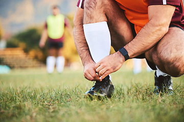 Image showing Rugby, hands and athlete tie shoes to start workout, exercise or fitness. Sports, player and man tying boots in training preparation, game or competition for healthy body or wellness on field outdoor