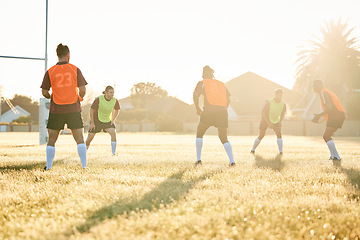 Image showing Team, practice or rugby men in training, exercise or workout match on sports field playing in summer. Sunshine, group or people ready for competitive game challenge with physical fitness or wellness