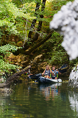 Image showing A young couple enjoying an idyllic kayak ride in the middle of a beautiful river surrounded by forest greenery