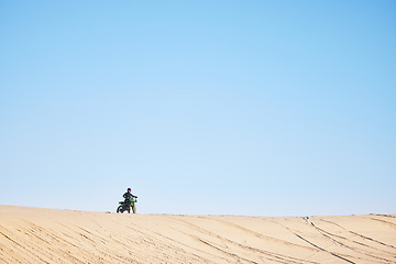 Image showing Motorcycle race, desert and sand with space, blue sky background and outdoor for off road challenge in summer. Motorbike, person and dirt trail for performance, power and fast adventure for mockup