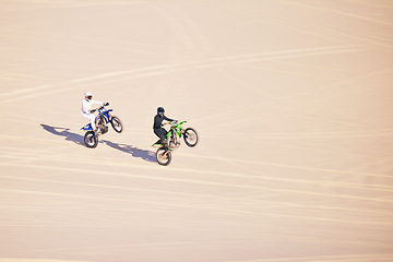 Image showing Motorcycle, sand and sports with people in the desert for adrenaline, adventure or training in nature. Bike, summer and freedom with friends outdoor together to wheelie while riding on mockup space