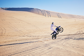 Image showing Bike, sports and space with a man in the desert for adrenaline, adventure or training in nature. Moto, fitness and freedom with an athlete riding a motorcycle for energy or balance on sand in Dubai