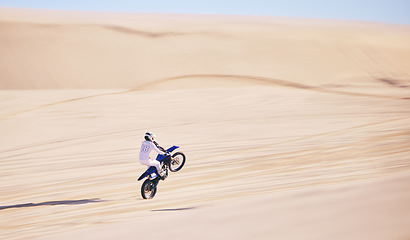 Image showing Bike, sand and fitness with a man in the desert for adrenaline, adventure or training in nature. Motorcycle, speed and balance with an athlete riding a sports vehicle on space in summer for freedom