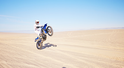 Image showing Desert, motorbike and sports person travel, journey and driving on off road adventure, freedom and balance on bike. Motorcycle, extreme action or athlete driver, racer or rider training on sand dunes