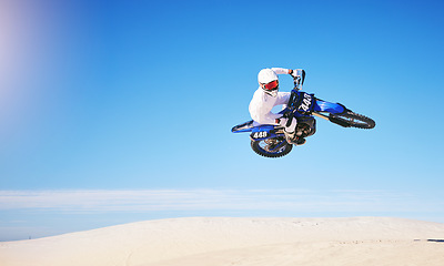 Image showing Race, motorbike jump and person in desert, action and extreme sport with speed outdoor and mockup space. Adventure, fitness and blue sky, motorcycle jump stunt and freedom, challenge and performance