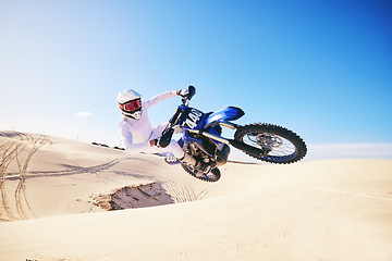Image showing Sand, motor sports and man in air with motorbike for adrenaline, adventure and freedom in desert. Action, extreme sport and male person on bike on dunes for training, exercise and race or challenge