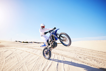 Image showing Sand, motorbike balance and sports person doing trick, skill or stunt on off road challenge, training and freestyle competition. Driving motorcycle, nature cycling or athlete driver on desert dunes