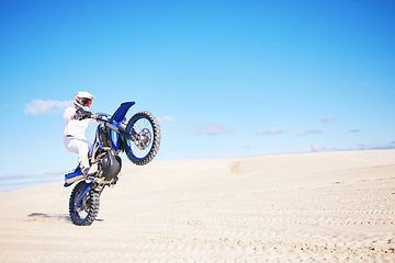 Image showing Bike, mockup and balance with a man in a desert for fitness or an adrenaline hobby on space. Motorcycle, skill and summer with a male sports athlete riding a vehicle in Dubai for freedom or energy