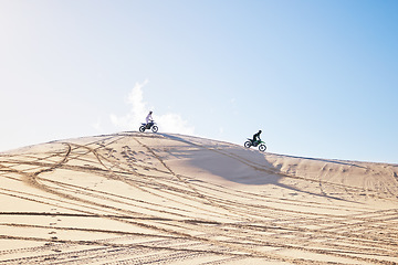 Image showing Desert, motorbike race or sports person travel, journey and driving on off road rally, outdoor challenge or bike competition. Fast motorcycle, speed or extreme athlete training on sand dunes in Dubai