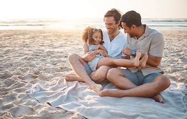Image showing Gay parents, father and girl at beach with love, smile and hug for vacation, laugh or outdoor on sand in sunset. LGBTQ men, young kid and adoption with family, holiday or comic conversation in summer