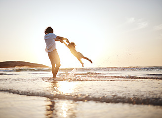 Image showing Girl child, swing and father by ocean, sunset and speed for game, holding hands or waves in summer. Young female kid, dad and spin in air, sand or happy for family bonding, love or care in sunshine