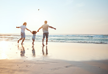 Image showing Gay parents holding hands with girl at beach running in water on holiday, vacation and adventure. Lgbtq family, sunset and happy child with fathers by ocean for bonding, relaxing and fun outdoors