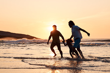 Image showing Lgbt family on beach, men and child holding hands at sunset, running in waves and island holiday together. Love, happiness and sun, gay couple on tropical ocean vacation with daughter in silhouette.