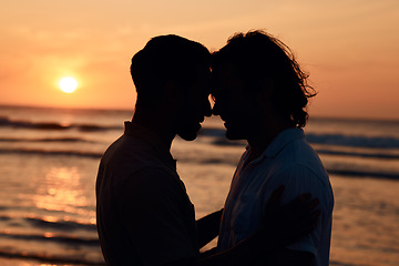 Image showing Silhouette, kiss and gay couple on beach, sunset and love on summer island vacation together in Thailand. Sunshine, ocean and romance, lgbt men in nature and fun holiday with pride, sea and waves.