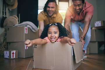 Image showing Family home, girl and box with father, push and gay parents with games, portrait and excited on floor with moving. LGBTQ men, female kid and cardboard package for car, airplane and speed in new house