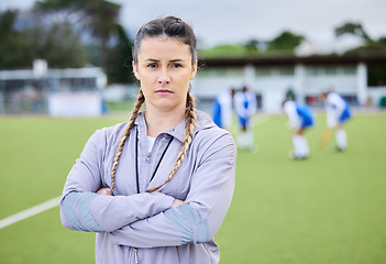 Image showing Woman coach, arms crossed and field for sports, hockey and portrait for teaching, fitness and exercise. Girl, serious face and guide for development, leadership and training for competition on grass