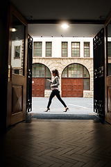 Image showing Phone, door and a woman tourist walking in the city on an overseas trip to search for directions to a location. Building, architecture and travel with a person in an urban town for a vacation abroad