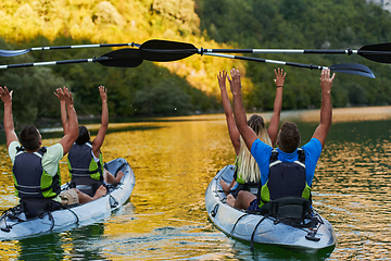 Image showing A group of friends enjoying having fun and kayaking while exploring the calm river, surrounding forest and large natural river canyons