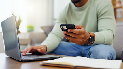 Image showing Phone, laptop and man hands typing while doing research for a freelance project in his living room. Technology, keyboard and male freelancer working online with a computer and cellphone at his home.