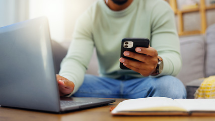 Image showing Phone, laptop and man hands typing while doing research for a freelance project in his living room. Technology, keyboard and male freelancer working online with a computer and cellphone at his home.