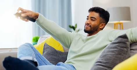 Image showing Watching tv, relax man and happy on sofa, streaming movies and news on television in living room in house. Calm person in home with remote for subscription service online on the couch in apartment