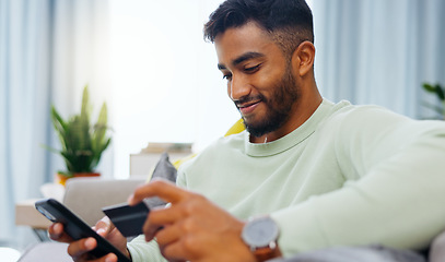 Image showing Credit card, finance and man with smartphone for online shopping in lounge at home. Indian, visa and money for e commerce transaction and search the internet for investment or product.