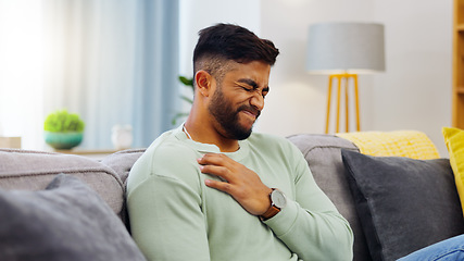 Image showing Man, sofa and chest pain in home, massage and relief from stress or injury in living room. Health, wellness and self care, person on couch with asthma, heartburn or breathing problem in apartment