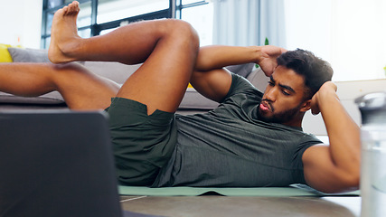 Image showing Fitness man, home workout and laptop while watching online exercise tutorial in the living room at home. Fit and active man doing crunches for abs while using internet for a health and wellness blog