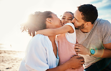 Image showing Family, beach and parents kiss child with travel and bonding, love and happiness together outdoor. Tropical vacation, ocean and happy people in nature, man and woman with kid, sunshine and adventure