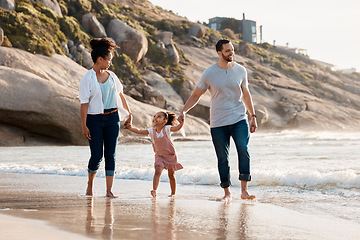 Image showing Family, beach and holding hands, parents and child with travel and bonding, love and walking together outdoor. Vacation, ocean and happy people in nature, man and woman with kid, sun and adventure