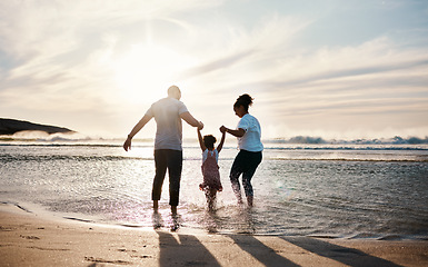Image showing Family play in ocean, beach and holding hands, parents and girl child with back view, fun in the sun and bonding outdoor. Happy people, freedom and adventure, splash in water and tropical holiday
