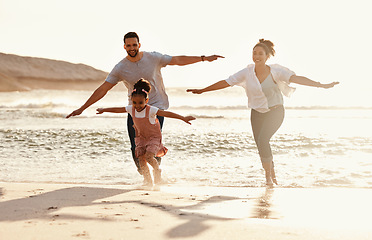 Image showing Family, running in ocean and freedom on beach with sunshine, fun together with games and bonding on vacation. Travel, adventure and playful, parents and child with happy people in nature and energy
