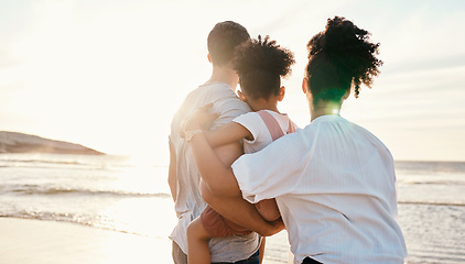 Image showing Family, beach and watching sunset, travel and bonding, love with back view and together outdoor. Vacation, ocean and people in nature, man and woman with kid, sunshine and adventure with peace