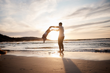 Image showing Swing, love and father with girl child at a beach holding hands in nature for play, freedom or bond at sunset. Ocean, travel and parent with kid at sea for spinning fun, games or celebration in Bali