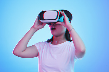 Image showing Woman, VR and glasses with wow in futuristic experience, 3d games and gen z education or digital e learning. Young person or student in virtual reality, high tech and vision on blue studio background