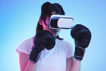 Image showing AI, metaverse and a sports woman boxing on a blue background in studio for fitness or exercise. Virtual reality, gamer and training with a young female boxer playing an online fantasy game for health