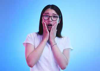 Image showing Surprise, open mouth and face of Asian woman with wow expression or shocked for drama, deal and promotion. Omg, wtf and portrait of person with discount emoji isolated in a studio blue background