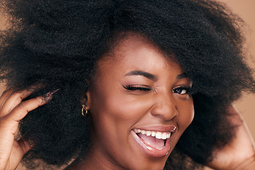 Image showing Portrait, hair and wink with a natural black woman in studio on a brown background for organic cosmetics. Beauty, face and haircare with a happy young afro female person indoor for shampoo treatment