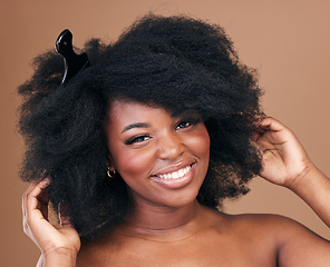 Image showing Portrait, hair and comb for beauty with a black woman in studio on a brown background for natural cosmetics. Face, smile and haircare with a happy young afro female model indoor for shampoo treatment